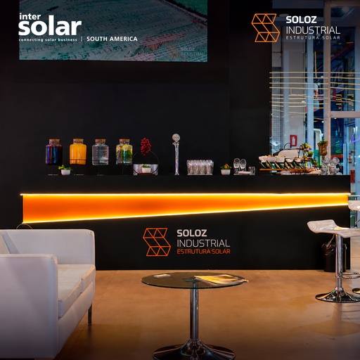 Área de recepção e convivência do estande da Soloz Industrial na Intersolar South America 2026